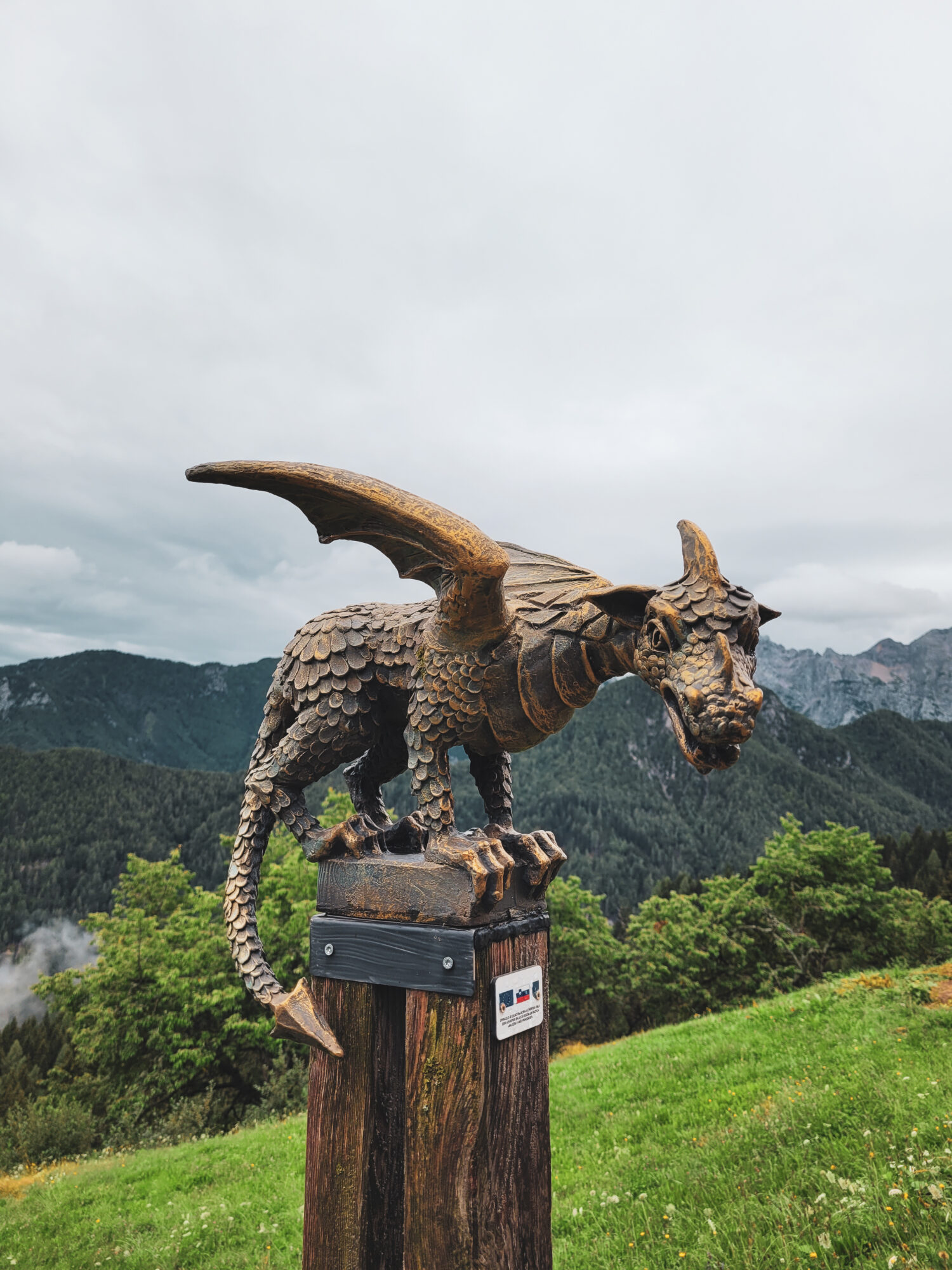 Un petit dragon en bronze perché sur un poteau qui borde la route panoramique Solcava, Slovénie